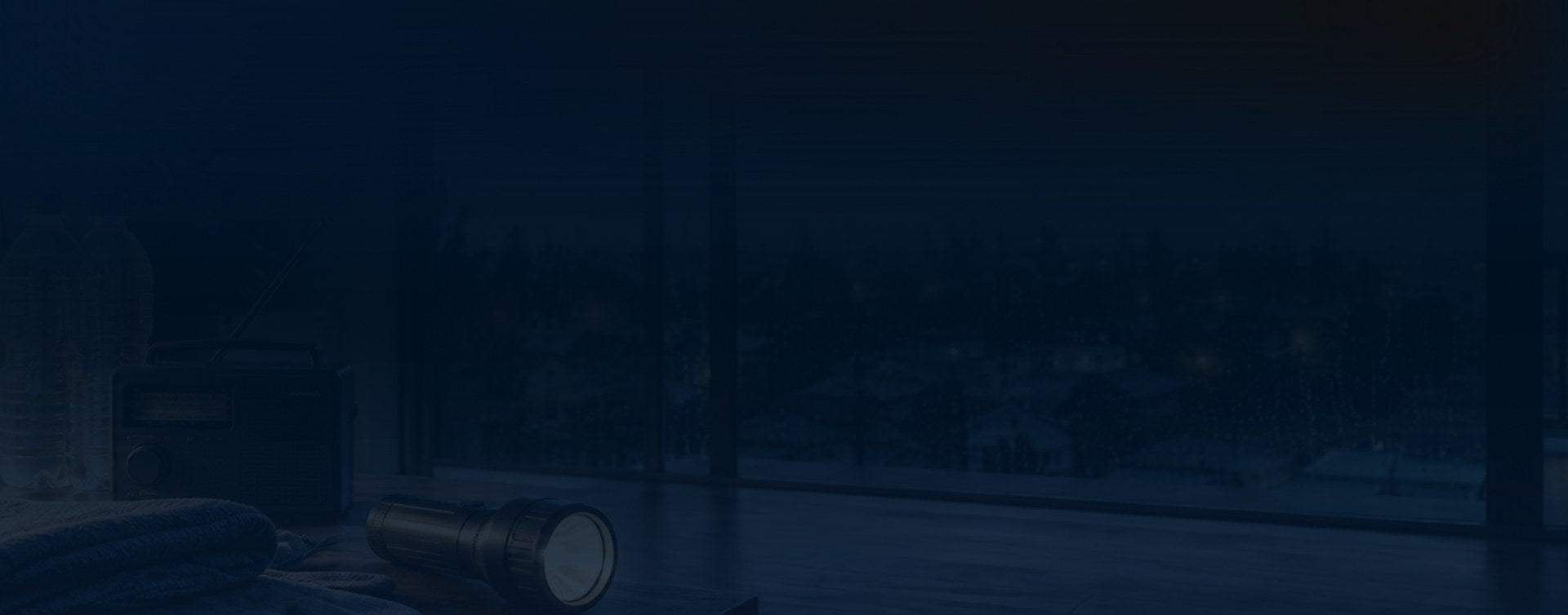Dark preparedness scene with a radio and flashlight by a window